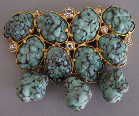 Aqua glass nuggets resembling turquoise dominate this circa-1940 gold-tone dress clip.