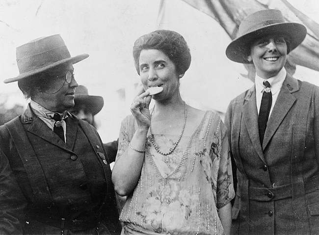 Top: A bright cookie advertisement from the 1950s. Above: Flanked by two early troop leaders, First Lady Grace Coolidge takes a dainty bite from a Girl Scout cookie in 1923.