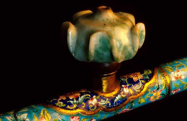 A close-up of an opium pipe of featuring Canton enamel and a jade bowl.