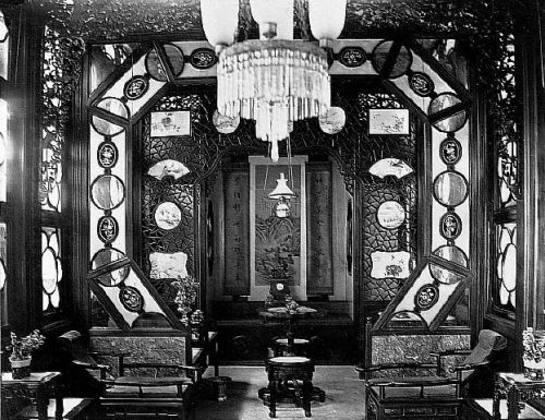 A luxurious and ornately decorated opium smoking room, possibly inside one of the "flower boat" that could be hired for a night of opium smoking on the Pearl River. The opium bed is at the back of the room. Circa 1880.