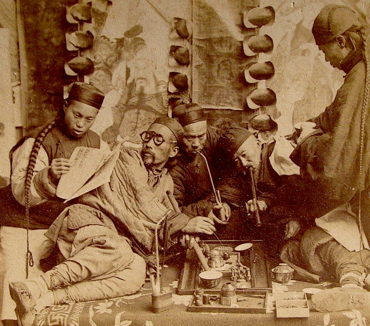 This photo depicting opium smoking in Canton, China, was posed in a studio for a stereoview card, circa 1900. 