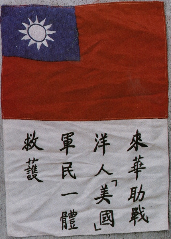 A hand-embroidered blood chit has a Republic of China flag and a Chinese message promising a reward to anyone who helped the airman get back to Allied lines.