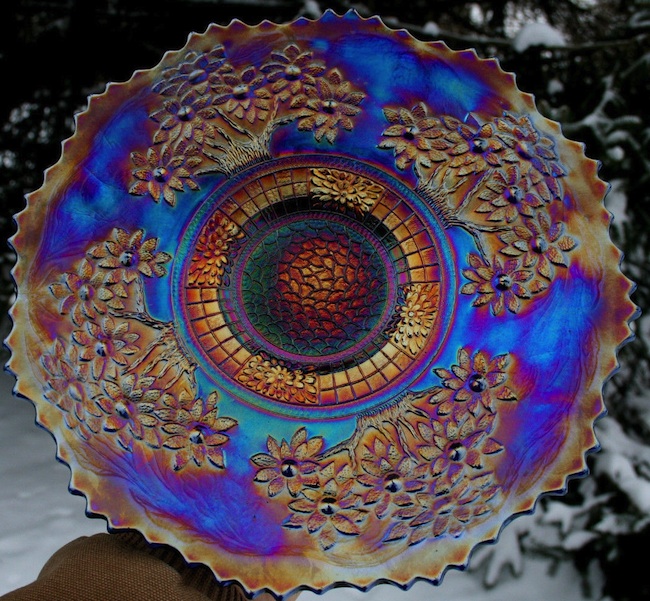 Carnival glass pieces, like this Fenton Orange Tree plate, were given away as prizes at carnivals and movie theaters in the 1910s and '20s. With orange iridescence on a base of electric blue, this plate qualifies as kitsch.