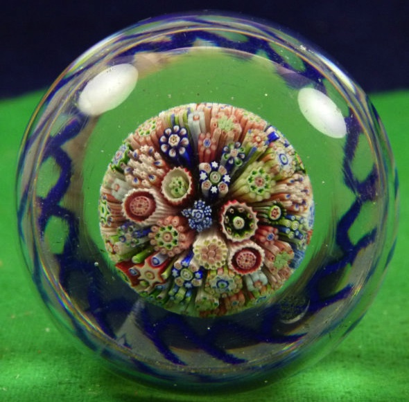 This Baccarat millefiori mushroom glass paperweight with torsade around the base is thought to be from the 1800s. The millefiori affect is created by slicing the ends of clusters of colored glass canes so viewers can see the flower-like patterns.