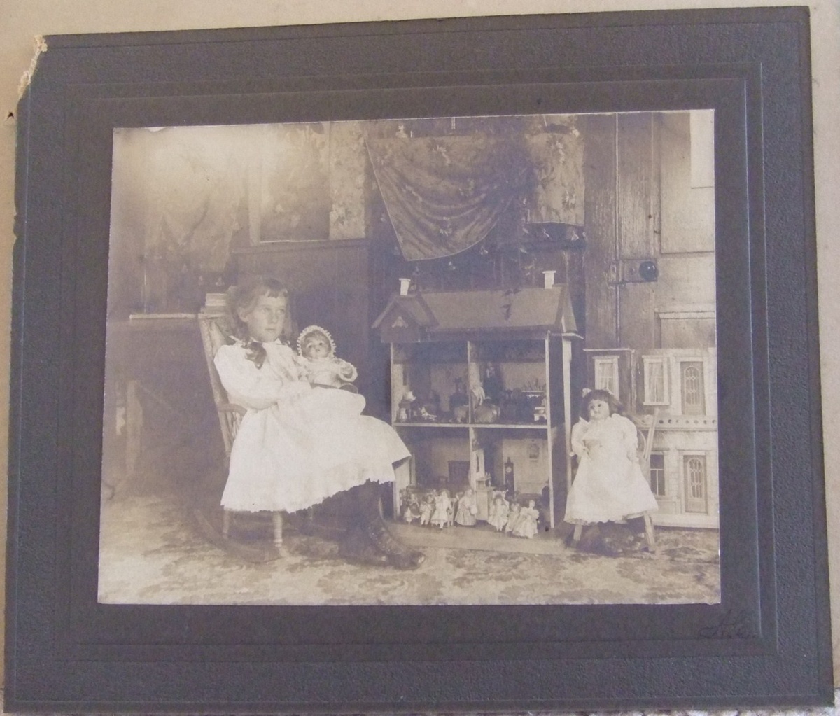 Photograph of Girl with dolls and doll house