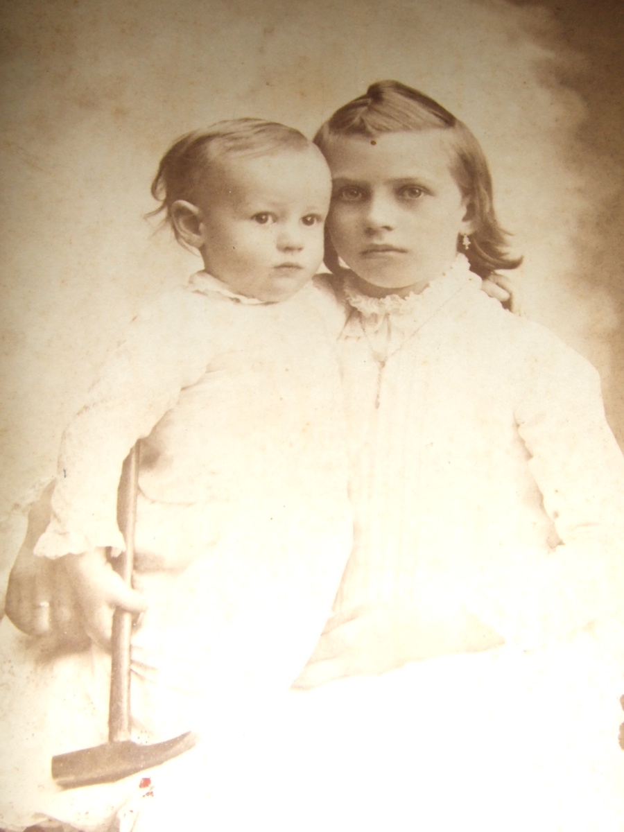 Cabinet card of two children with one holding a hammer